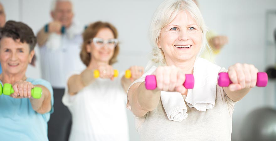 A group of older women working out with dumbells