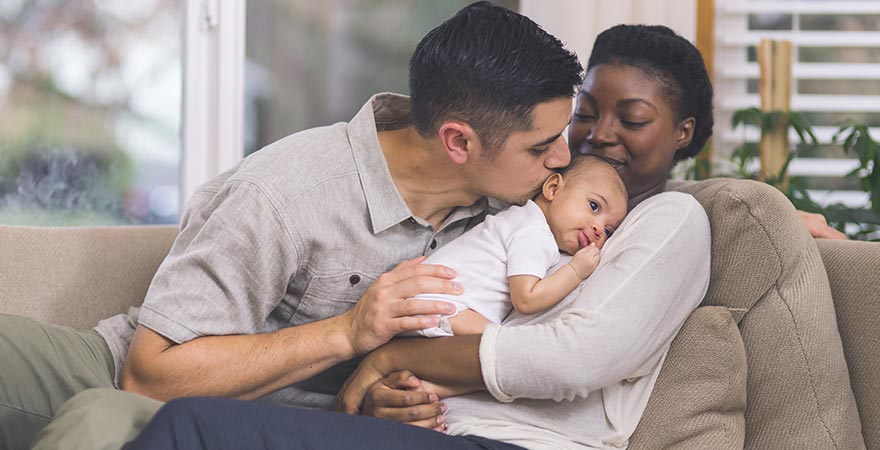 A mother and father holding their baby