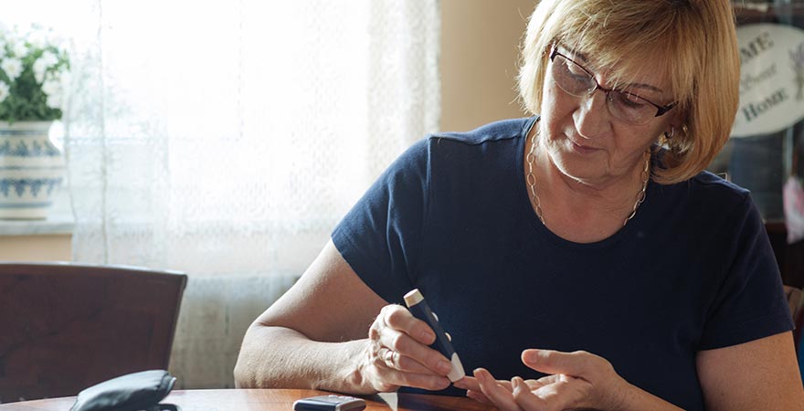 An older woman checking her blood glucose levels