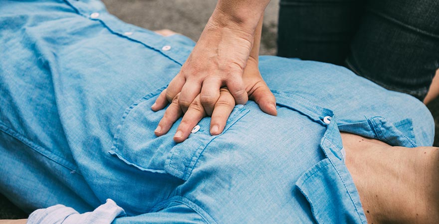 A man giving chest compressions to a human