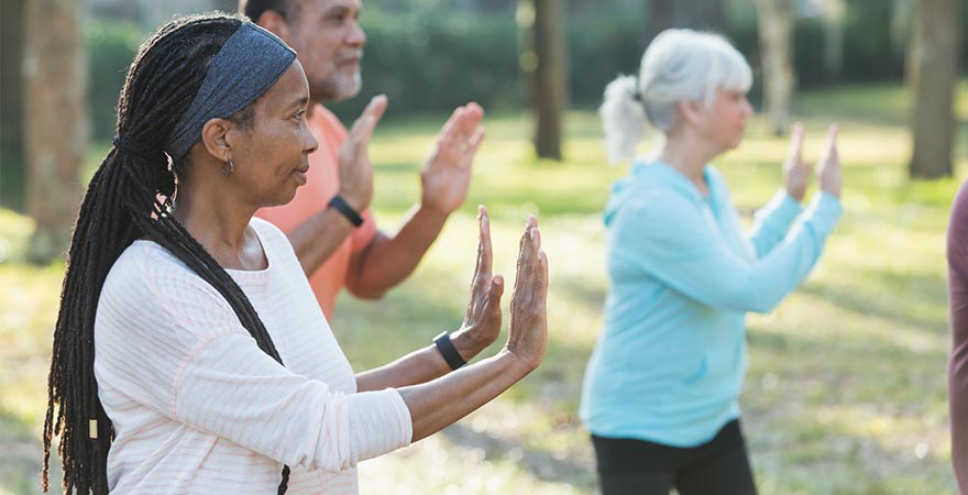 A group of women doing Tai Chi outdoors