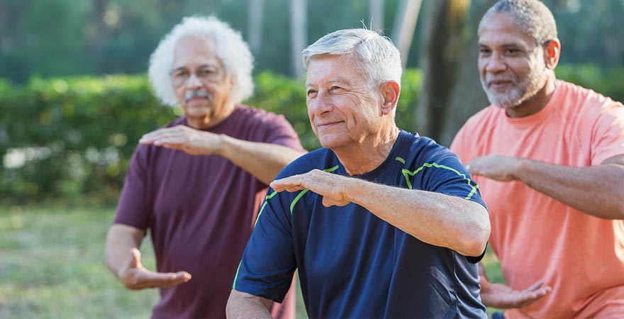 A group of men doing Tai Chi outdoors
