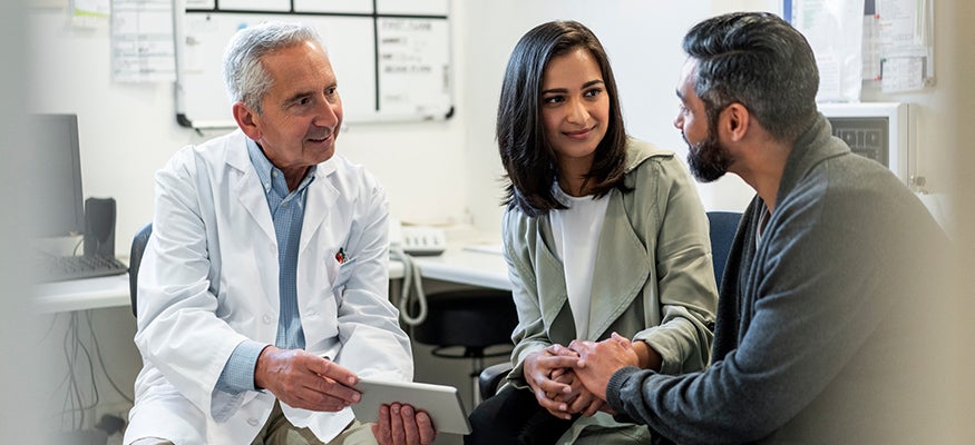 doctor talking with a patient over a tablet