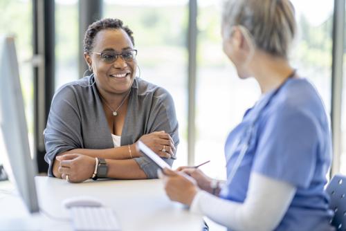 Black woman speaking with a nurse about a mammogram