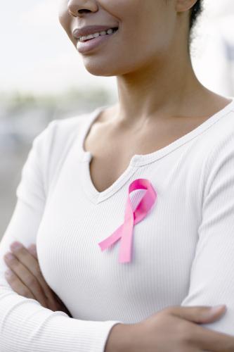 woman smiling with breast cancer pink ribbon