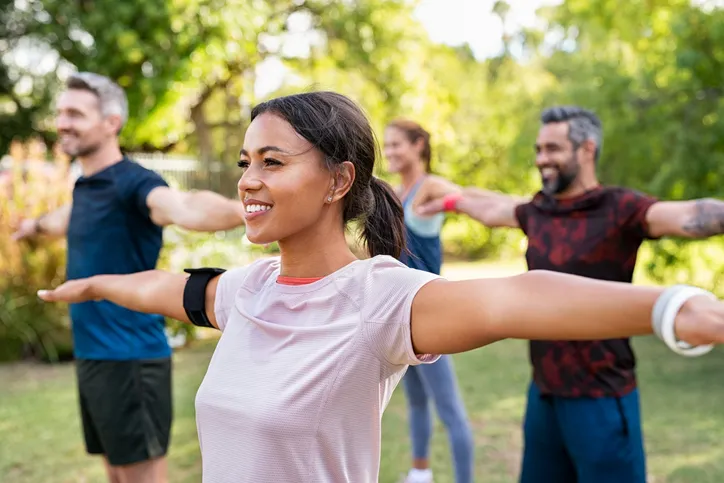 a woman exercising in the park with friends