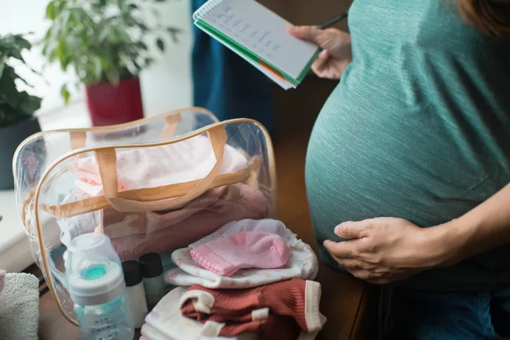 pregnant woman preparing bag for hospital