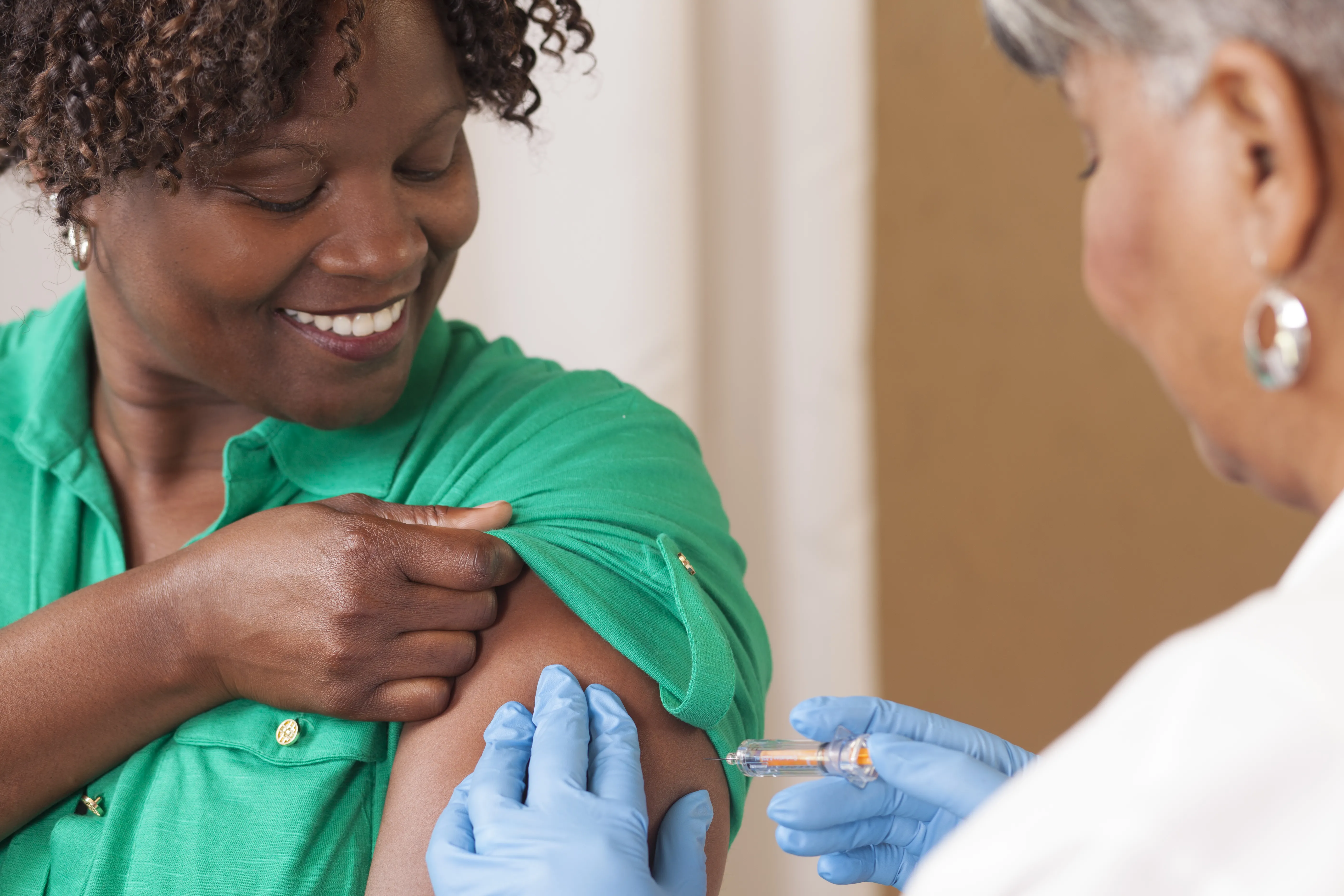 Doctor Administering Flu Shot To Woman