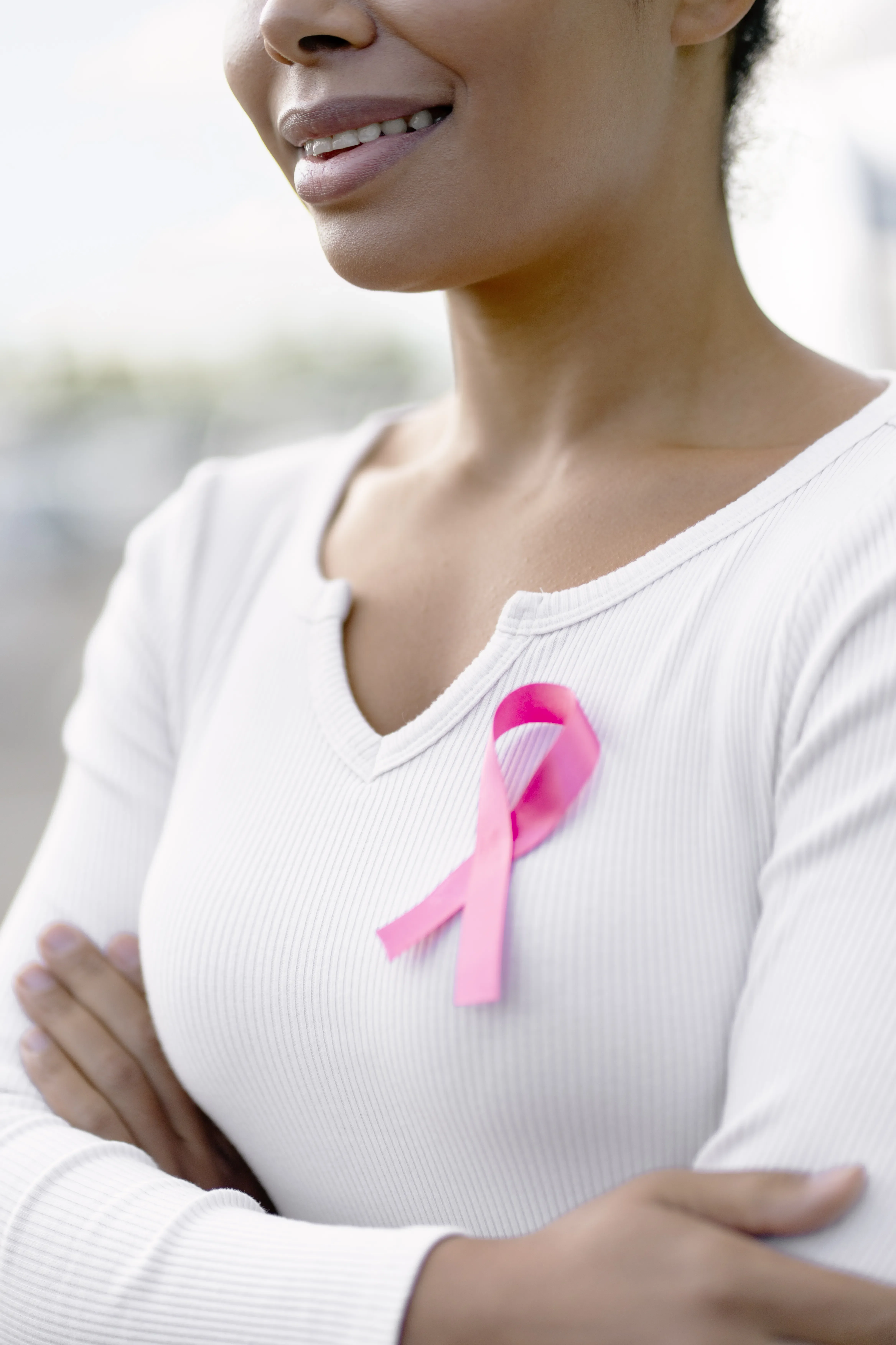 woman smiling with breast cancer pink ribbon